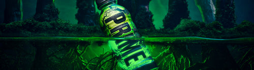 PRIME Glowberry hydration drink bottle partially submerged in glowing green water, set against a dark, eerie forest background. The bottle's glow-in-the-dark design is emphasized, highlighting the PRIME branding and the unique Glowberry flavor.