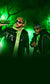 Logan Paul holding a bottle of PRIME Glowberry hydration drink, standing next to KSI. Both are dressed in green-themed outfits with sunglasses, set against a glowing green background with eerie tree silhouettes.